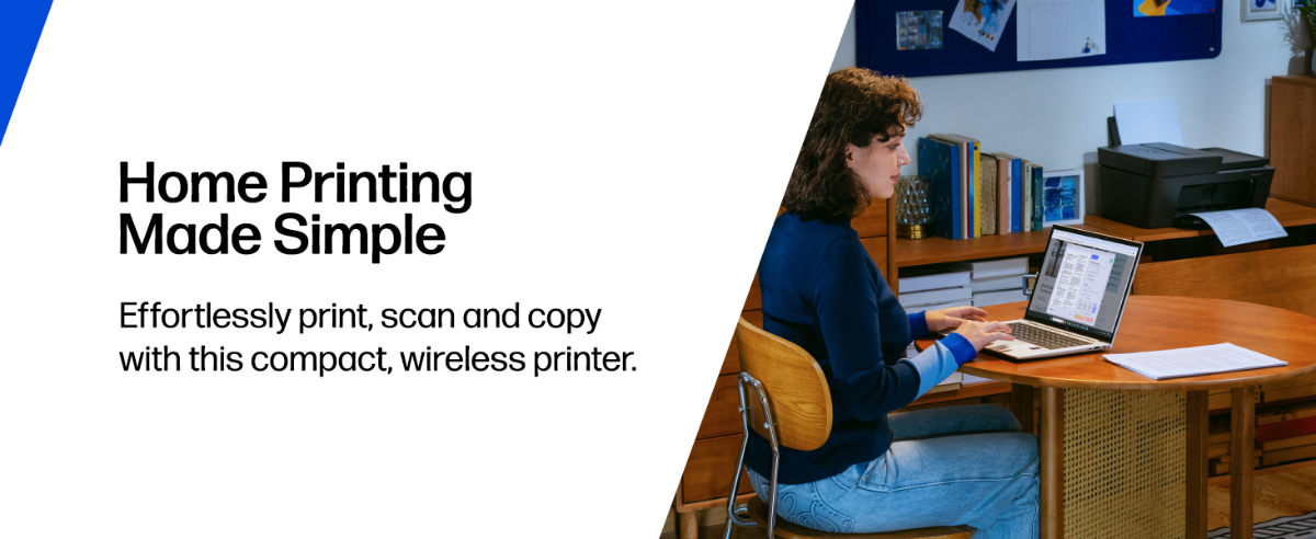 A person works on a laptop at a desk beside a wireless home printer.