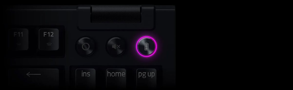Close-up of a black keyboard's top right corner, featuring a battery lock icon illuminated with purple/pink ring.