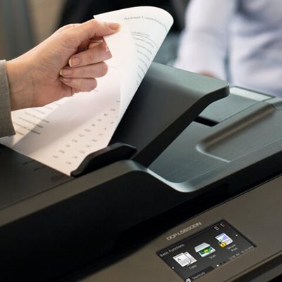 Person loading a double-sided document into the multifunction printer's automatic document feed for scanning