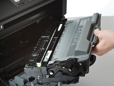 Person inserting toner cartridge into laser printer