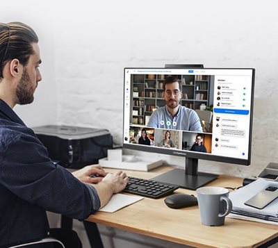 A man using a desktop computer for a video conference call.