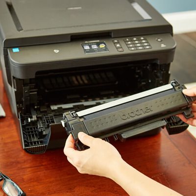 Person inserting new toner cartridge into laser printer