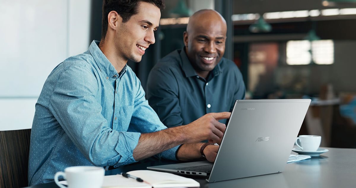Business professionals collaborating on a project using an laptop in a café.