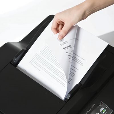 Person adding multi-page double-sided document into printer's automatic document feed for scanning
