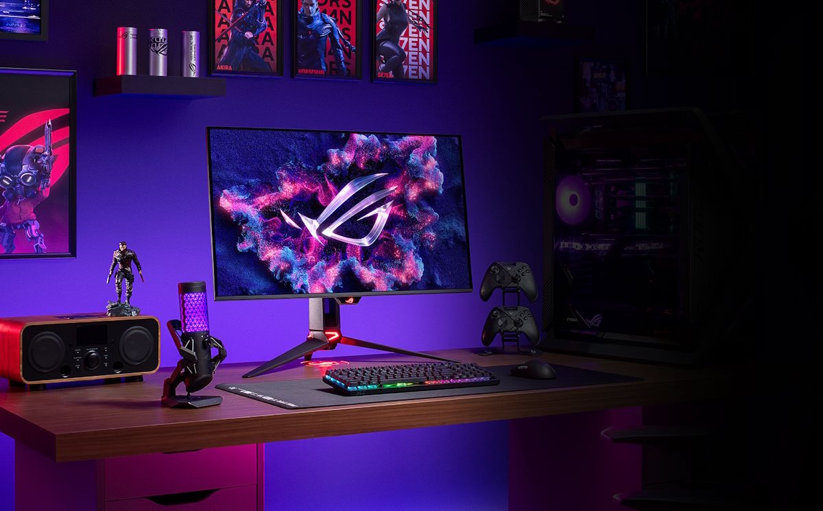 A gaming setup comprising of the PG32UCDM, two controllers, a microphone, a speaker, and keyboard.