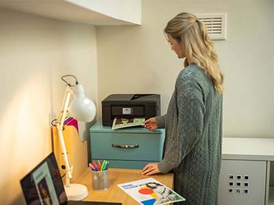 A woman removing print output from the Brother DCP-J1460DW