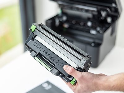 A man holding a Brother DCP-L1640W toner cartridge