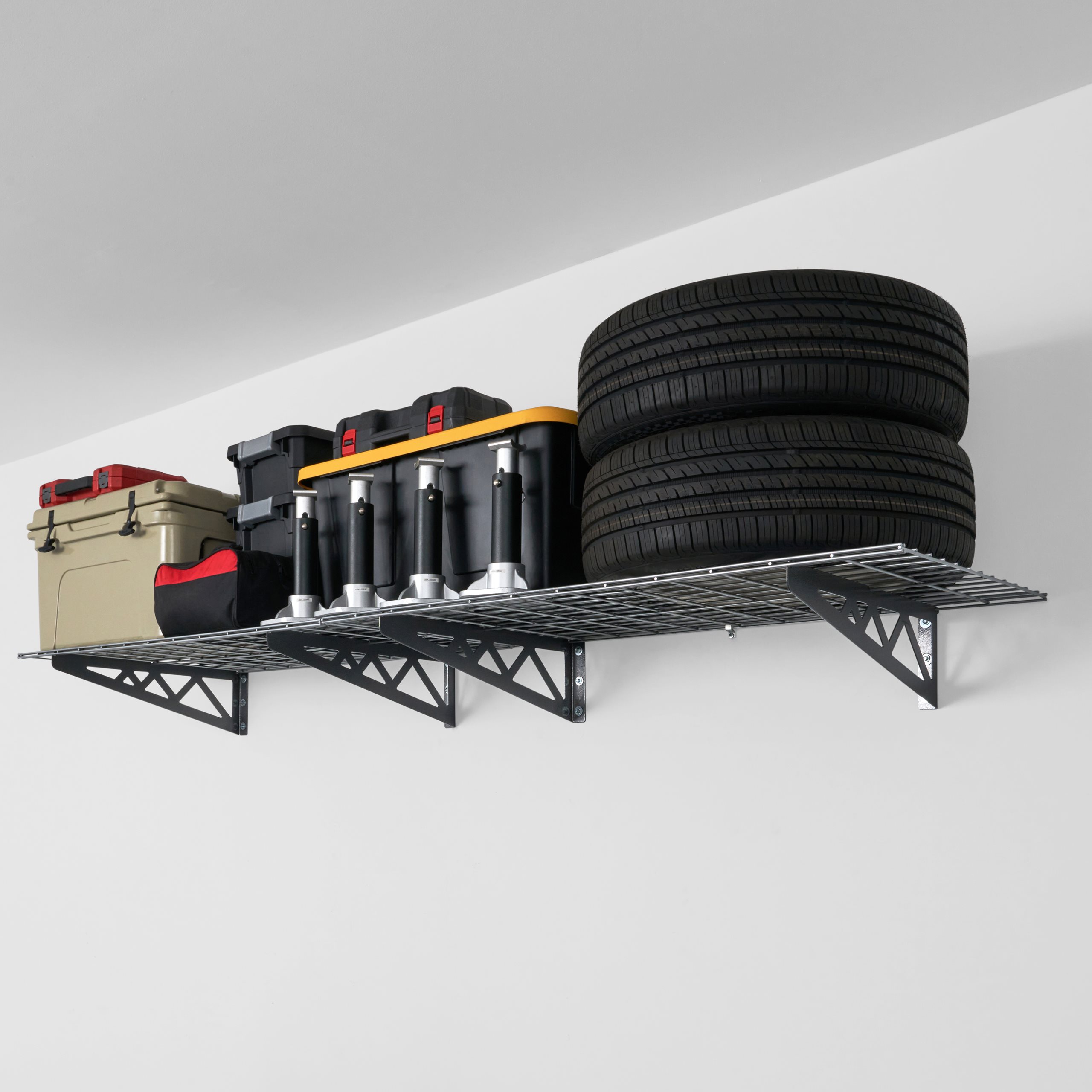 SafeRacks Wall Mounted Garage Shelving filled with storage bins, large tools, a cooler, and 2 tires.