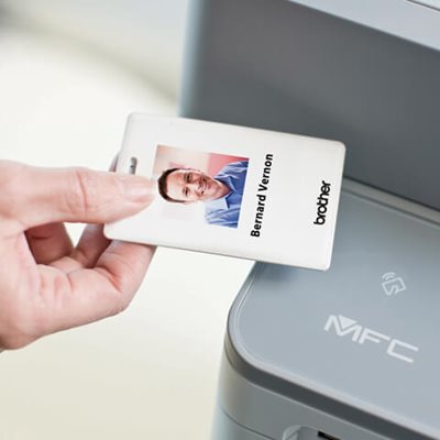 Person using NFC ID badge to release print job at printer station