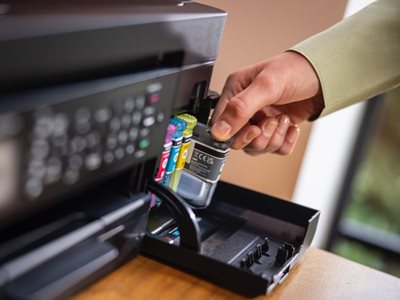 A woman installing an ink cartridge in a Brother MFC-J4350DW