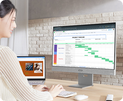 A young professional works on her laptop, using the ASUS ZenScreen Smart Monitor MS32UC as a larger second screen.