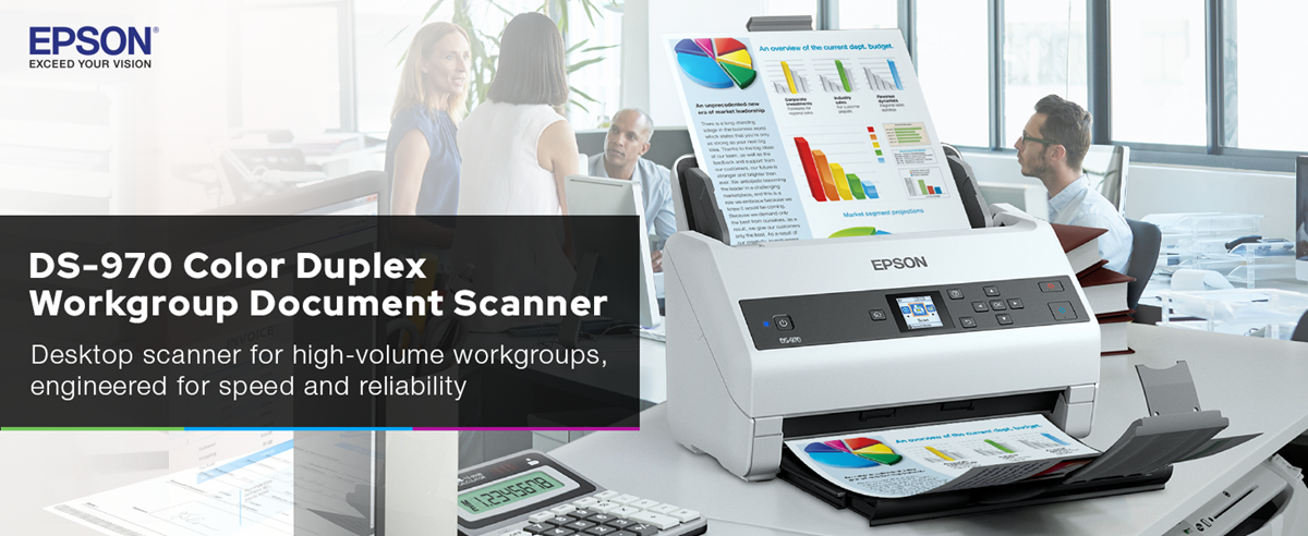 Document scanner in the foreground with a group of people in an office conversing behind it