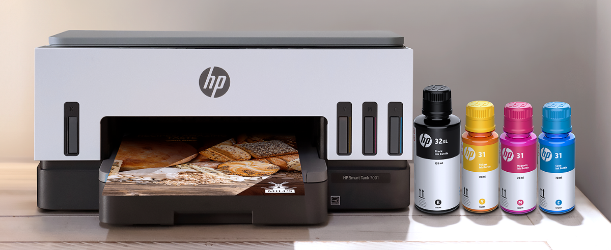 An HP Smart Tank 7001 printer outputting a photo with ink bottles nearby.