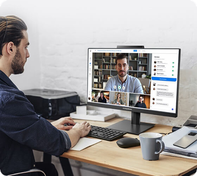 A man using a desktop computer for a video conference call.
