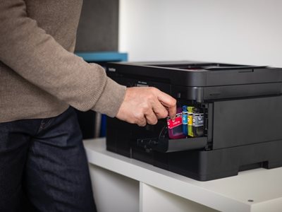 A man installing an ink cartridge in a Brother MFC-J4550DW