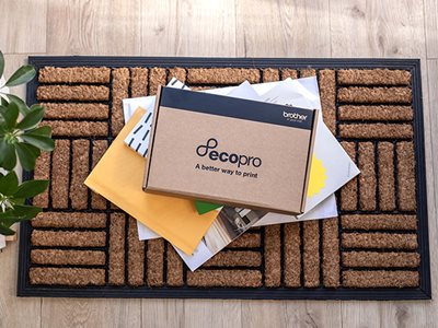 A Brother EcoPro supplies box and assorted post on an indoor doormat