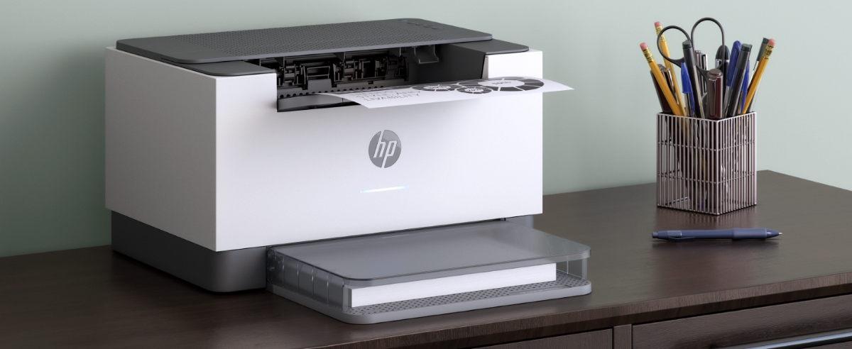An HP LaserJet printer outputting a document on a desk with office supplies.