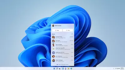 Picture of a laptop homepage with Microsoft Windows 11 blue logo as background and Microsoft Teams opened.