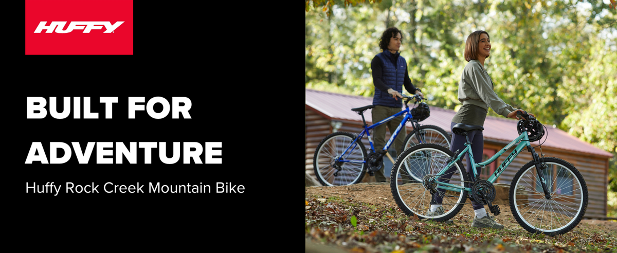 Huffy Rock Creek Mountain Bike in a woody background that is dark and shadowy