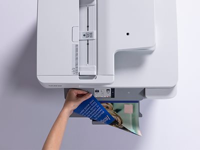 A woman removing colour print output from a Brother MFC-J6977DW