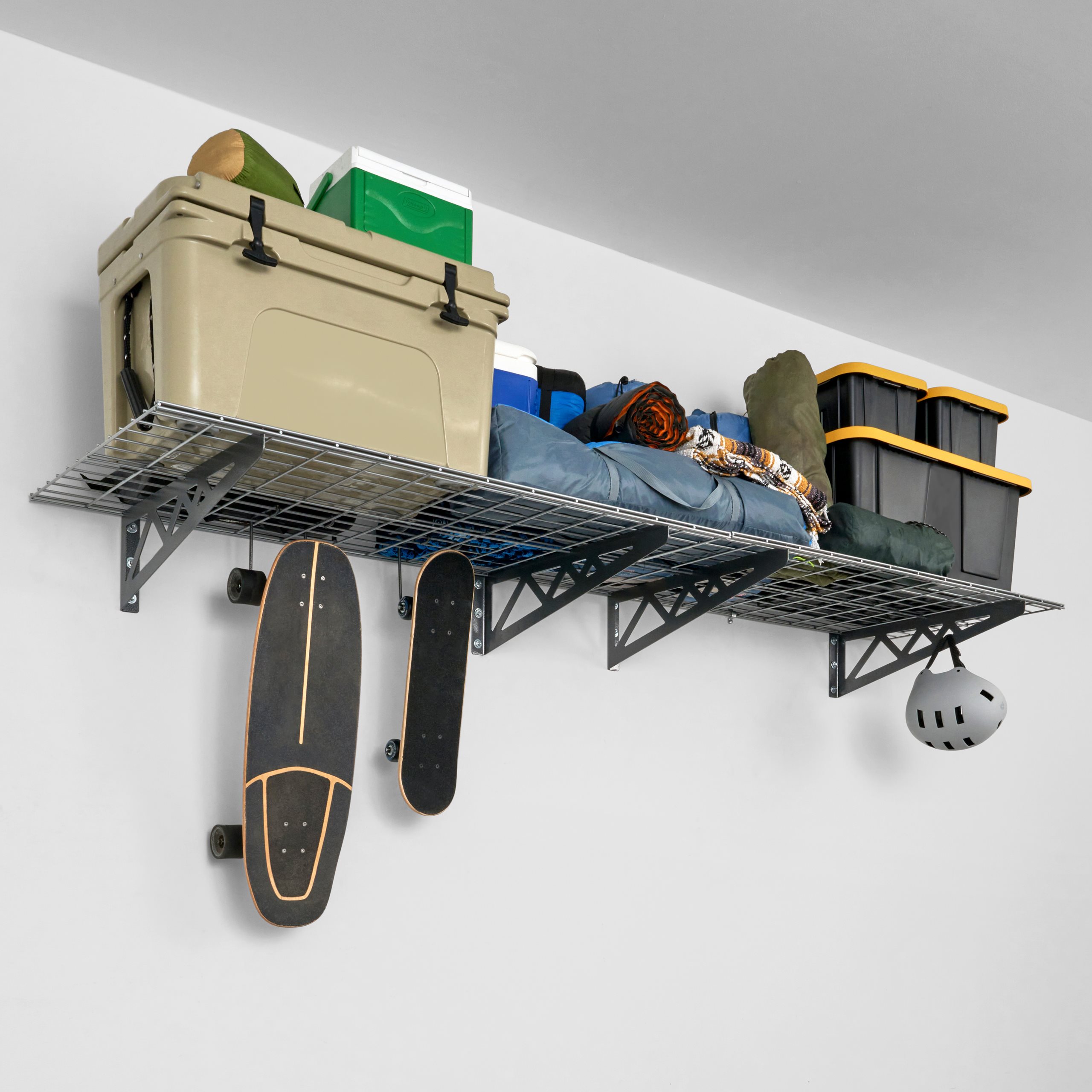 SafeRacks Wall Mounted Garage Shelving filled with storage bins, large tools, a cooler, 2 tires, and a skateboards and a helmet hanging from the accessory hooks.