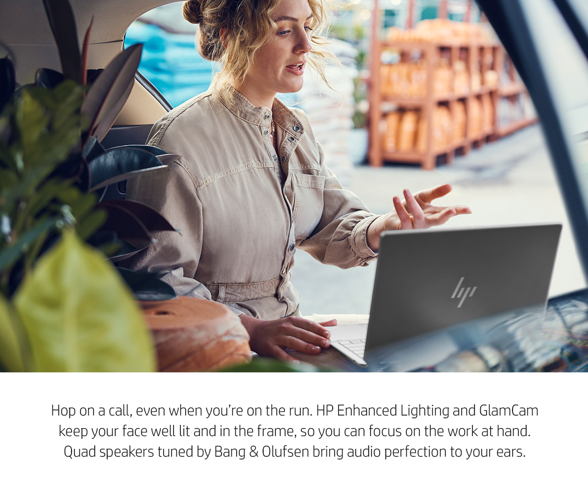 Busy young woman uses HP Spectre notebook to take a video call while doing errands