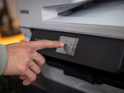 Close-up of a man using the built-in touchscreen to setup a Brother MFC-J6760DW printer