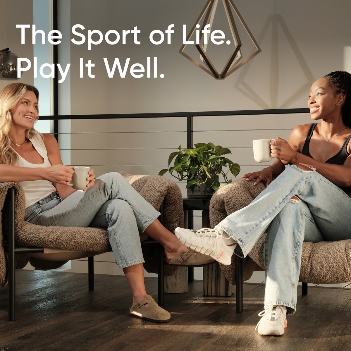 Image of two smiling women sitting with coffee cups in hand. Text reads: "The Sport of Life. Play it well."