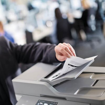 Person adding multi-page double-sided document into printer's automatic document feed for scanning