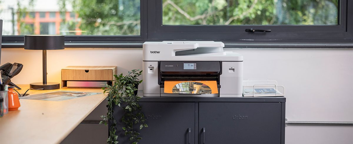 A Brother MFC-J6760DW on a grey cabinet in a home office environment