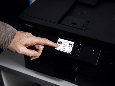 A man operating a Brother MFC-J4550DW through the colour touchscreen