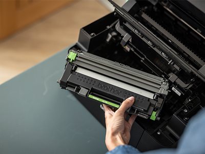 A woman holding a Brother DCP-L1660W toner cartridge