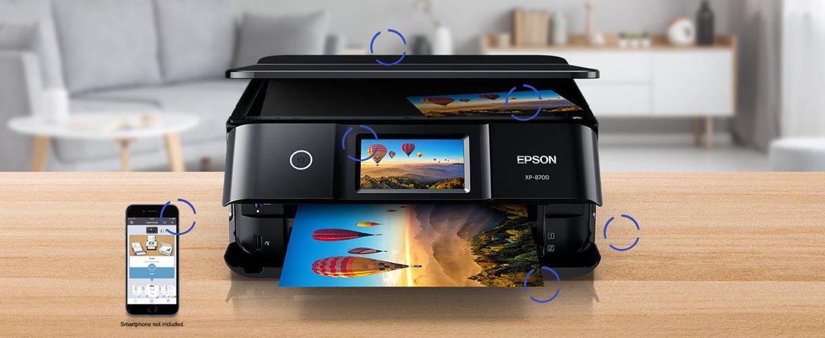Printer on a desk with a smartphone next to it.