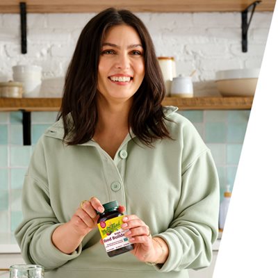 Woman smiling and holding a bottle of Blood Builder Minis