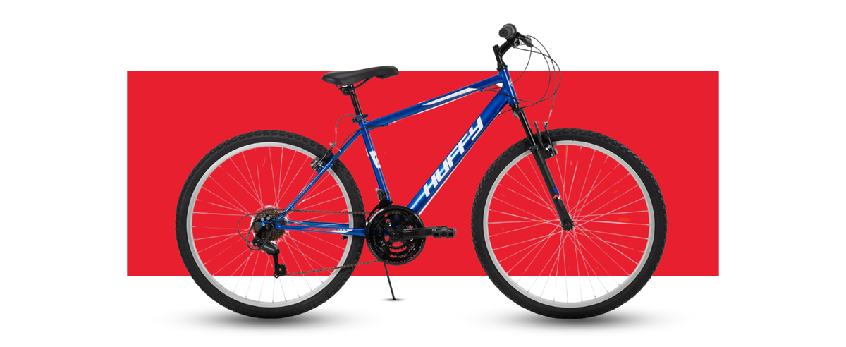 Side profile of the Huffy Rock Creek mountain bike on a red background showcasing the features of the bike.