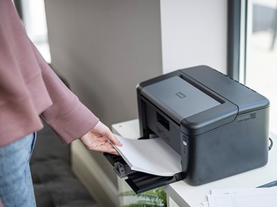 A woman removing print output from the Brother HL-L1240W