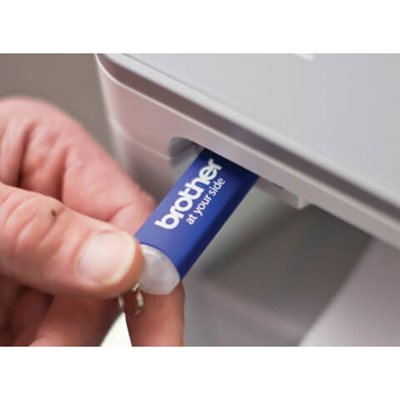 Close-up of person inserting USB drive into printer's USB port