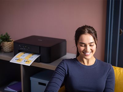A woman sat in front of a Brother DCP-J1260DW, on a shelving unit