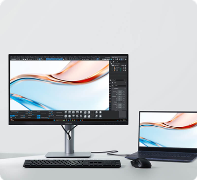 A sleek desktop setup showing a ProArt monitor displaying vibrant digital art beside a laptop.