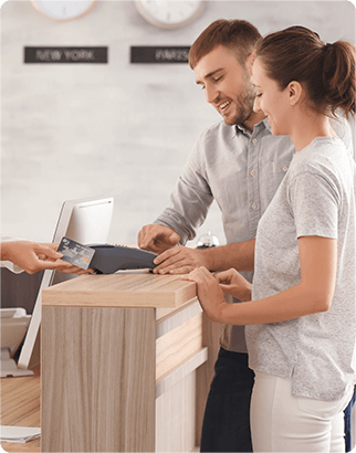Two travelers checking in at the hotel counter