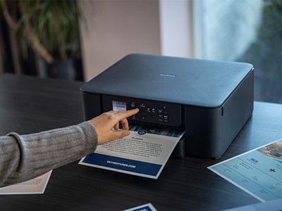 A woman operating a Brother DCP-J1310DW through the colour touchscreen