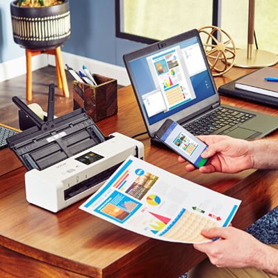 Man at desk, scanning a document to his mobile phone